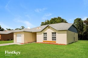 La Belle house for rent - a beige house with a garage and a green lawn