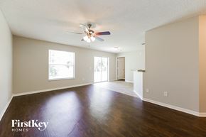 La Belle house for rent - the living room and dining room of an empty house with a ceiling fan