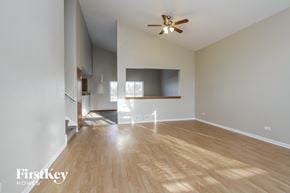 Bolingbrook house for rent - A spacious room with wooden floors and a ceiling fan.