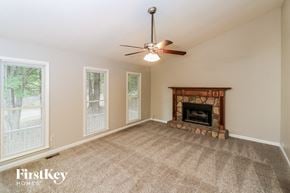 Dallas house for rent - a living room with a fireplace and a ceiling fan