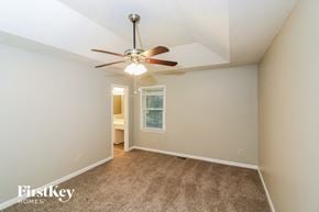 Dallas house for rent - a bedroom with a ceiling fan and a carpeted floor