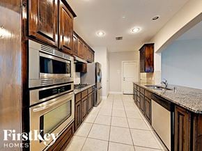 Fate house for rent - a kitchen with stainless steel appliances and wooden cabinets