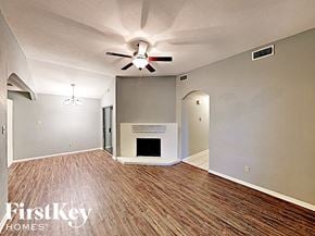 Arlington house for rent - an empty living room with a ceiling fan and a fireplace