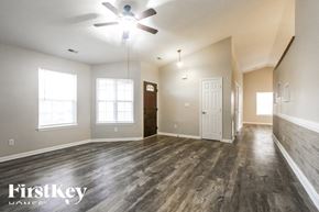 Indianapolis house for rent - A spacious room with wood flooring and a ceiling fan.