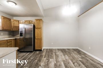 Indianapolis house for rent - A kitchen with wooden cabinets and a refrigerator.