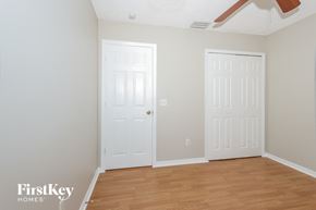 Port St. Lucie house for rent - a bedroom with two white doors and a wood floor