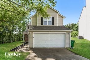 Charlotte house for rent - a white garage door on a tan house with a driveway