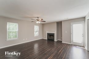 Charlotte house for rent - a living room with a ceiling fan and a fireplace