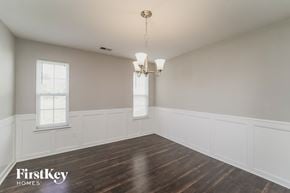 Charlotte house for rent - a dining room with white walls and wood floors and a chandelier