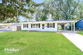 Hazelwood house for rent - a white house with a lawn and a blue shed