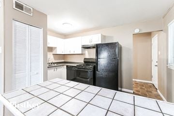 Hazelwood house for rent - a kitchen with a black refrigerator and a black stove