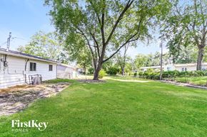 Hazelwood house for rent - a backyard with a house and a yard with grass and trees