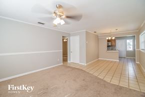 Saint Cloud house for rent - A spacious room with a ceiling fan and beige carpeting.