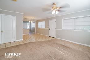 Saint Cloud house for rent - A spacious room with a fan and carpeted floor.