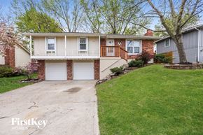 Kansas City house for rent - a white and brick house with a driveway and a lawn