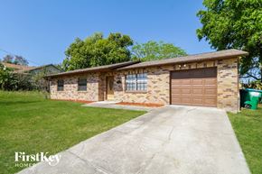 Deltona house for rent - A house with a brown garage door is for sale.