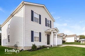 Wentzville house for rent - A house with a white siding and a black door is shown.