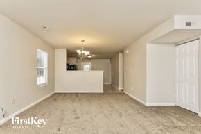 Wentzville house for rent - A spacious room with a chandelier and a white door.