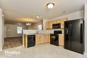 Wentzville house for rent - A kitchen with black appliances and wooden cabinets.