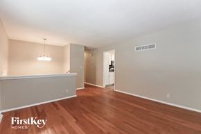 Raymore house for rent - A room with wooden floors and a chandelier hanging from the ceiling.