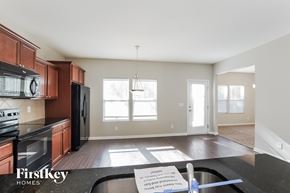 Charlotte house for rent - an empty kitchen with wood floors and a black counter top