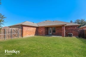 Lancaster house for rent - the backyard of a brick house with a yard and a fence