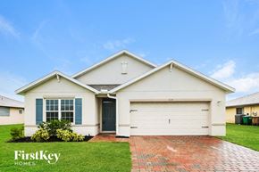 Cape Coral house for rent - a white house with a garage door and grass