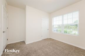 Cape Coral house for rent - a bedroom with carpet and a door and window