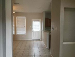 Desoto house for rent - an empty living room with a tile floor and a white door