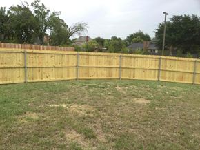 Desoto house for rent - a wooden fence in a backyard with a grass field