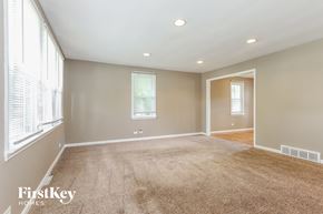 Bensenville house for rent - a living room with a carpeted floor and a large window