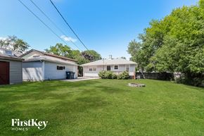 Bensenville house for rent - a backyard with a house and a yard with grass and a fence