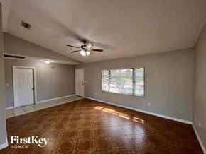 Port Charlotte house for rent - A room with a brown floor and a ceiling fan.