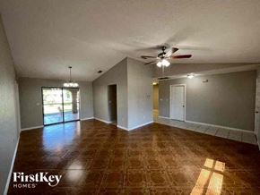 Port Charlotte house for rent - A room with a ceiling fan and a large window.