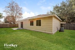 Apopka house for rent - a small tan building in a backyard with a lawn and a fence