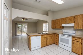 Apopka house for rent - a kitchen with white appliances and wooden cabinets