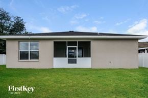 Valrico house for rent - A house with a beige exterior and a white fence.