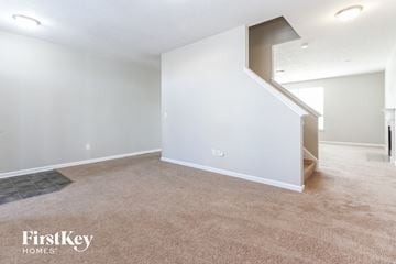 Indianapolis house for rent - a living room with white walls and carpet and a staircase