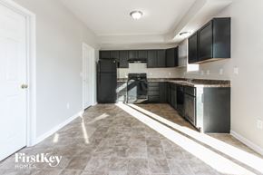 Indianapolis house for rent - an empty kitchen with black cabinets and stainless steel appliances