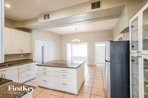 Hollywood house for rent - A kitchen with white cabinets and a black refrigerator.