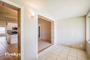 Hollywood house for rent - A spacious room with a tiled floor and a doorway leading to another room.