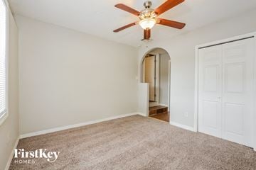 Apopka house for rent - a spacious living room with carpet and a ceiling fan
