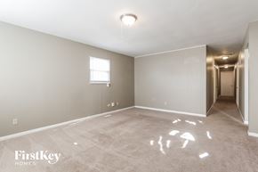 Indianapolis house for rent - a empty living room with a door to a hallway and a window