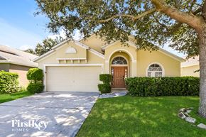 Winter Haven house for rent - A house with a garage and a tree in front of it.