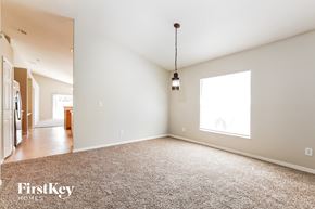 Winter Haven house for rent - A large, empty room with a carpeted floor and a hanging light fixture.