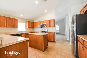 Winter Haven house for rent - A kitchen with wooden cabinets and a black refrigerator.