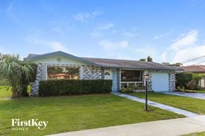 Coconut Creek house for rent - A house with a blue roof and a sign that says "FirstKey Homes".