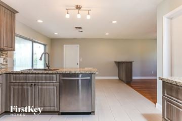 Coconut Creek house for rent - A kitchen with a stainless steel dishwasher and a granite countertop.