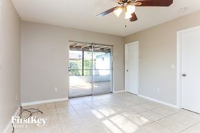 Coconut Creek house for rent - A spacious room with a ceiling fan and sliding glass doors leading to a balcony.