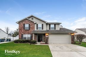 Indianapolis house for rent - a house with a garage door and a lawn